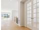 Bright, open hallway featuring hardwood floors, French doors, and views of the home's open layout at 10730 Hanging Lake Pl, Parker, CO 80138