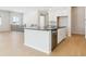 Modern kitchen island with stainless steel appliances and views to the open living area at 10730 Hanging Lake Pl, Parker, CO 80138