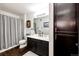 Well-lit bathroom featuring a shower-tub combo and a dark vanity at 5439 S Dover St # 101, Littleton, CO 80123