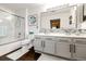 Bright bathroom featuring a glass shower enclosure and a white dual-sink vanity at 5439 S Dover St # 101, Littleton, CO 80123