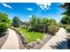 Lush green community space with walking paths, landscaping, and a fenced area at 5439 S Dover St # 101, Littleton, CO 80123