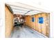 Empty garage interior with plywood walls, exposed framing, shelving, and open door at 5439 S Dover St # 101, Littleton, CO 80123