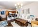 Open concept living area with a modern chandelier, flowing into a kitchen with a bar and island seating at 5439 S Dover St # 101, Littleton, CO 80123