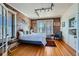 Spacious bedroom with exposed brick wall and hardwood floors at 1378 N Ogden St # 12, Denver, CO 80218