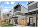Modern townhome featuring balconies, gray and white stucco, wooden fencing, and well-manicured lawn at 1735 Lowell Blvd, Denver, CO 80204
