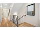 Hallway featuring hardwood floors, modern railings, and a window creating a bright and open feel at 1735 Lowell Blvd, Denver, CO 80204