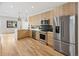 Well-lit kitchen with stainless steel appliances, light wood cabinets, and green backsplash tiles at 1735 Lowell Blvd, Denver, CO 80204