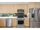 A full view of the kitchen with light wood cabinets, stainless steel appliances, and white countertops at 1735 Lowell Blvd, Denver, CO 80204