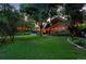 Expansive backyard with lush green lawn, mature trees, and charming string lights for outdoor enjoyment at 4766 S Fillmore Ct, Cherry Hills Village, CO 80113
