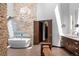 Elegant bathroom with a freestanding tub, stone accent wall, and modern chandelier for a luxurious feel at 4766 S Fillmore Ct, Cherry Hills Village, CO 80113