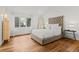 Bright bedroom features wood floors, a tufted headboard, and large windows with scenic outdoor views at 4766 S Fillmore Ct, Cherry Hills Village, CO 80113