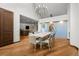 Dining room features wood floors, modern table with seating, pendant lighting, and view into kitchen at 4766 S Fillmore Ct, Cherry Hills Village, CO 80113
