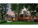 Elegant home with a stone facade, large windows, mature trees, and a well-manicured lawn, providing exceptional curb appeal at 4766 S Fillmore Ct, Cherry Hills Village, CO 80113