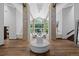Grand foyer boasts soaring ceilings, wooden floors, stone columns, and a striking chandelier creating a dramatic entrance at 4766 S Fillmore Ct, Cherry Hills Village, CO 80113