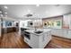 Spacious kitchen with double islands, stone backsplash, hardwood floors, and stainless appliances at 4766 S Fillmore Ct, Cherry Hills Village, CO 80113