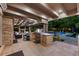 Beautiful outdoor kitchen and patio featuring a grill, fireplace, TV, and pool view, creating the ultimate backyard experience at 4766 S Fillmore Ct, Cherry Hills Village, CO 80113