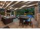 Covered outdoor patio with a stone fireplace and comfortable seating, perfect for entertaining and relaxing by the pool at 4766 S Fillmore Ct, Cherry Hills Village, CO 80113