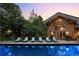 Inviting swimming pool with lounge chairs and umbrellas, set against the backdrop of a stunning home at 4766 S Fillmore Ct, Cherry Hills Village, CO 80113