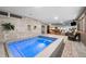 Stunning indoor spa with a vibrant blue-lit pool, stone accents, and an adjacent gym area, creating a luxurious wellness space at 4766 S Fillmore Ct, Cherry Hills Village, CO 80113