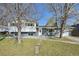 Charming gray split-level home with well-manicured lawn and mature trees at 1524 Twin Sisters Dr, Longmont, CO 80504