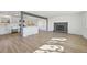 Bright living room with hardwood floors, white walls, fireplace, and updated kitchen at 1524 Twin Sisters Dr, Longmont, CO 80504