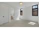 Sunlit bedroom with neutral carpet, bathroom access, and two windows for natural light at 735 S Elizabeth St, Denver, CO 80209
