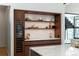 Modern kitchen featuring custom cabinetry with display shelves, a beverage cooler, and an island at 735 S Elizabeth St, Denver, CO 80209