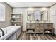 Modern bathroom with double sinks, wood cabinets, and a luxurious soaking tub at 62681 E Hampden Pl, Byers, CO 80103