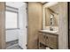 Modern bathroom featuring a wooden vanity and mirror, with plank wall siding and a separate toilet room at 62681 E Hampden Pl, Byers, CO 80103