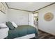 Cozy bedroom with wood trim, wood floors, and a view into the main living area at 62681 E Hampden Pl, Byers, CO 80103