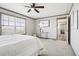 Comfortable bedroom with ceiling fan, carpeted floor, and wainscoting detail on the wall at 62681 E Hampden Pl, Byers, CO 80103