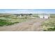 Home with a large shop, set back from the road, emphasizing the property's privacy and rural charm at 62681 E Hampden Pl, Byers, CO 80103