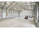 Spacious shop interior with high ceilings, ideal for storage or workshop, featuring durable concrete flooring at 62681 E Hampden Pl, Byers, CO 80103