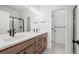 Modern bathroom with dual sinks, wooden cabinets, and a glass-enclosed shower at 2736 W 68Th Ave, Denver, CO 80221