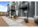 Townhome exterior showcasing gray siding, black railings, and well-maintained landscaping at 2736 W 68Th Ave, Denver, CO 80221