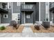 Modern townhome with gray siding, stone accents, a small porch, and tidy landscaping at 2736 W 68Th Ave, Denver, CO 80221