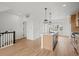 Bright, open kitchen with stainless steel appliances, an island and light wood floors at 2736 W 68Th Ave, Denver, CO 80221
