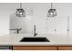 Kitchen island featuring a black sink, quartz countertops, and modern pendant lights at 2736 W 68Th Ave, Denver, CO 80221