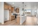 Open kitchen area with stainless steel appliances, island, and light wood flooring at 2736 W 68Th Ave, Denver, CO 80221