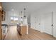 Open-concept layout with a kitchen island, stainless steel appliances, and light wood floors at 2736 W 68Th Ave, Denver, CO 80221