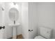 Stylish powder room with a pedestal sink, oval mirror, and a modern toilet at 2736 W 68Th Ave, Denver, CO 80221