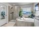 Bright bathroom featuring a soaking tub with elegant fixtures and separate glass-enclosed shower at 8255 S Vandriver Way, Aurora, CO 80016