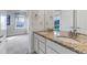 Bathroom featuring a double sink vanity with granite countertop and view to a bedroom at 8255 S Vandriver Way, Aurora, CO 80016