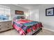Well-lit bedroom with a metal frame bed, colorful quilt, and bright pillows at 8255 S Vandriver Way, Aurora, CO 80016