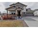 Charming two-story home featuring a covered front porch and a three-car garage at 8255 S Vandriver Way, Aurora, CO 80016