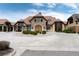 Stunning estate showcasing a circular driveway and stone facade with lush landscaping at 8255 S Vandriver Way, Aurora, CO 80016