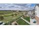 Scenic view of the golf course from the backyard featuring a green lawn and adjacent houses at 8255 S Vandriver Way, Aurora, CO 80016