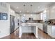 Modern kitchen boasts stainless steel appliances, granite countertops, and island with pendant lighting at 8255 S Vandriver Way, Aurora, CO 80016