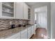 Granite countertop, tiled backsplash, and ample cabinet space in modern kitchen at 8255 S Vandriver Way, Aurora, CO 80016