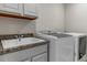 Functional laundry room featuring front loading washer and dryer next to a utility sink at 8255 S Vandriver Way, Aurora, CO 80016